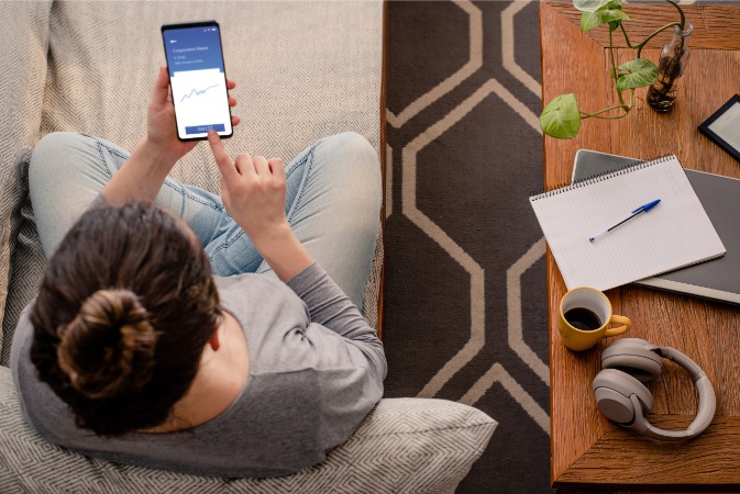a person sitting on the couch looking at their mobile phone